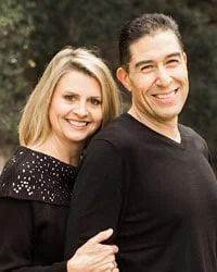 Two people standing close together outdoors