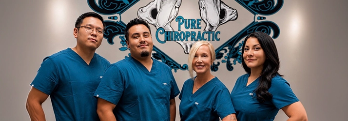 Yecenia Lopez and Seohyn Kwon and Their Team in Front of Pure Chiropractic Logo