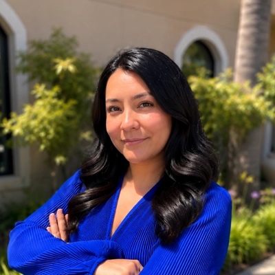 Dr. Yecenia Lopez smiling at camera in blue shirt