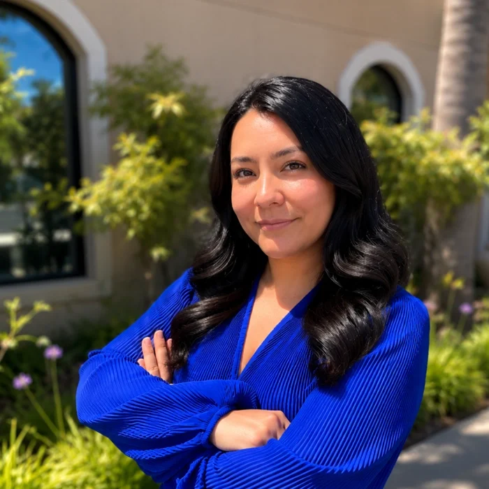 Dr. Yecenia Lopez smiling at camera in blue shirt